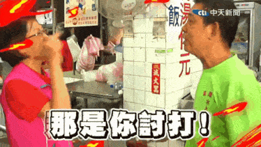 a man in a green shirt is talking to a woman in a pink shirt in front of a sign that says cti