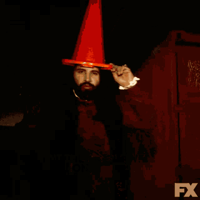 a man with a beard wearing an orange cone and the words we drank the blood of some people on the bottom