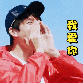 a man wearing a red jacket and a black hat covering his face with his hands