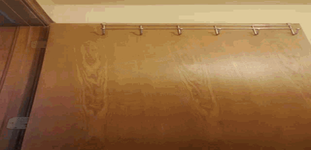 a wooden wall with hooks on it and a metal shelf