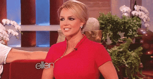 a woman in a red dress is sitting in front of a sign that says ellen .