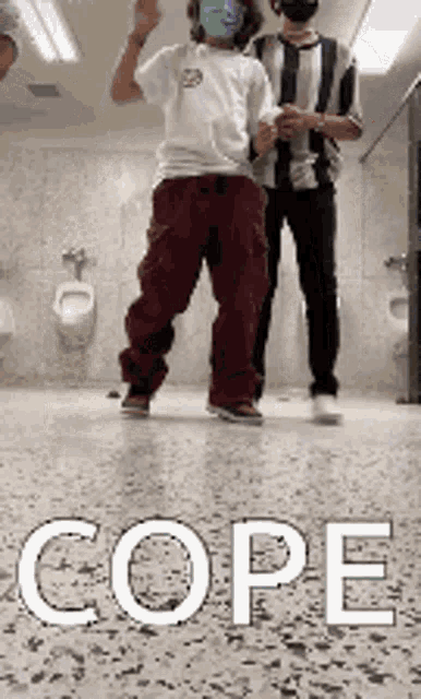 a man wearing a mask is dancing in a public restroom .