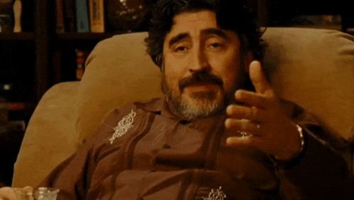 a man with a ring on his finger covers his mouth with his hand