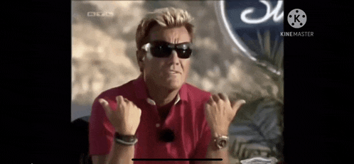 a man wearing sunglasses and a red polo shirt is making a funny face .