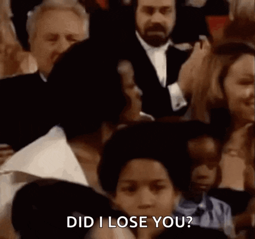 a group of people are sitting in a crowd and one of them is asking another person if they lost them .
