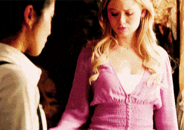a woman in a pink sweater stands next to another woman in a white shirt