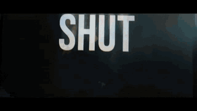 a man is standing in front of a wall with the words `` up '' written on it .