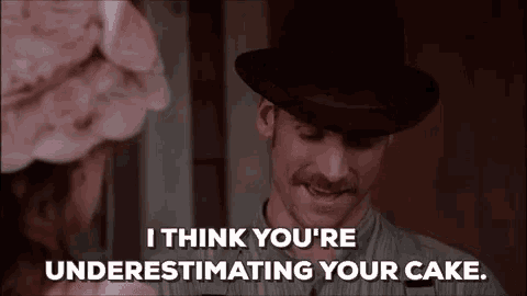 a man in a hat is talking to a woman and says `` i think you 're underestimating your cake '' .
