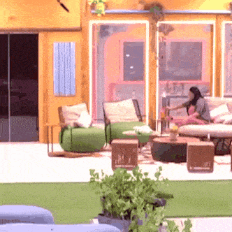 a woman sits on a couch in a living room surrounded by furniture