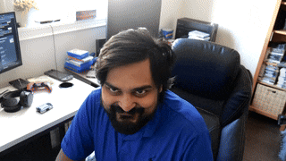 a man with a beard is sitting at a desk with a computer
