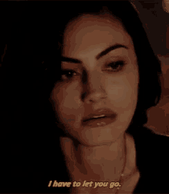 a close up of a woman covering her face with her hand in a dark room .