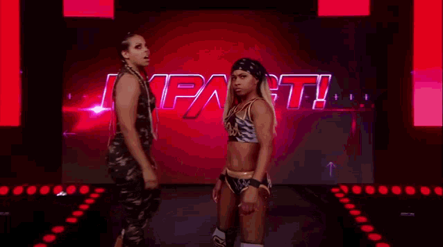 a couple of women standing next to each other on a stage .