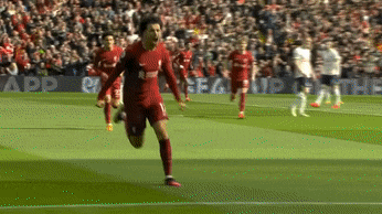 a soccer player in a red uniform runs on the field