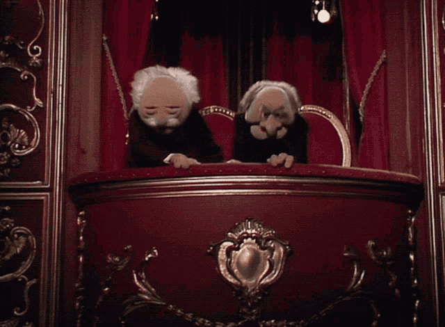 a couple of muppets are sitting on a stage