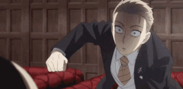 a man in a suit and tie is pointing his finger at someone