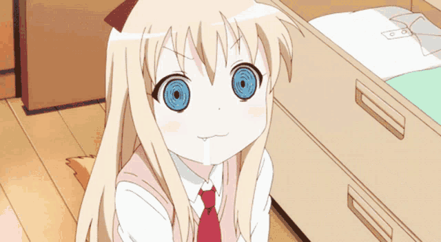 a girl with blonde hair and blue eyes is sitting next to a drawer