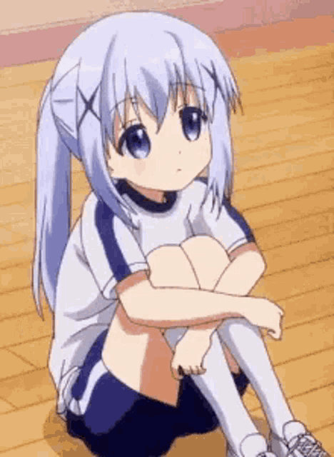 a girl with blue hair is sitting on the floor with her legs crossed and a sad look on her face .