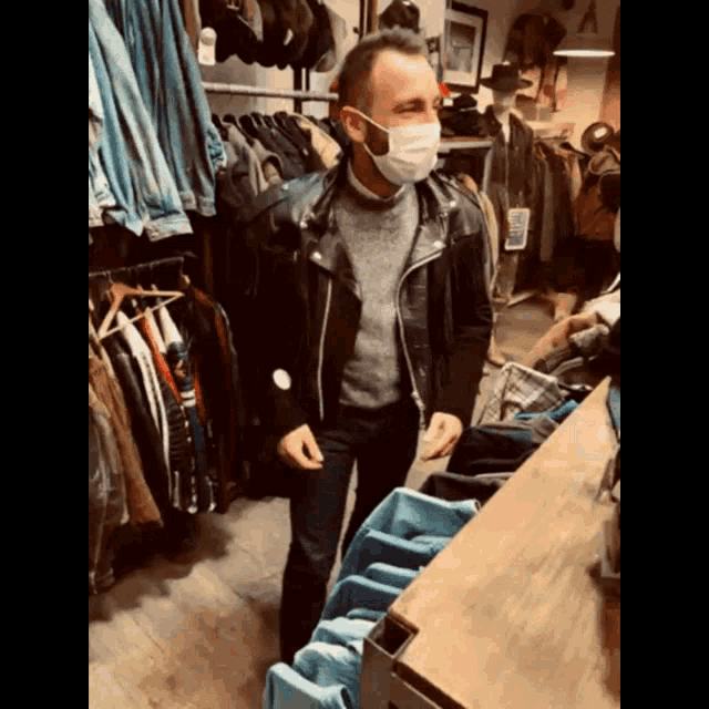 a man wearing a face mask is standing in a store