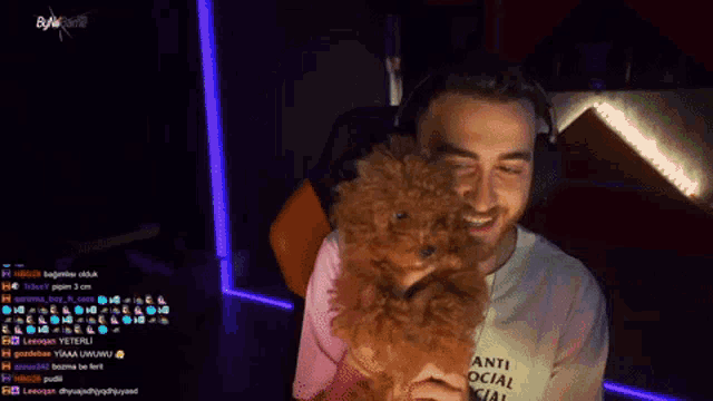 a man wearing headphones is holding a small brown dog in his lap