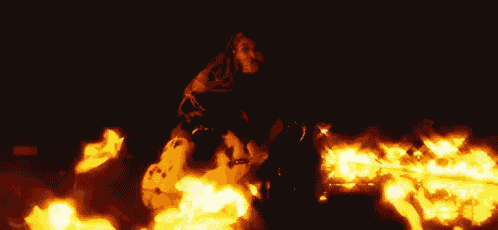 a woman is riding a horse through a fire .