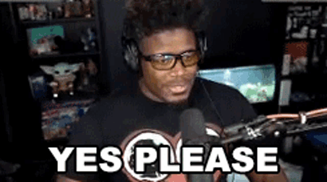 a man wearing glasses and headphones is standing in front of a microphone and saying `` yes please '' .