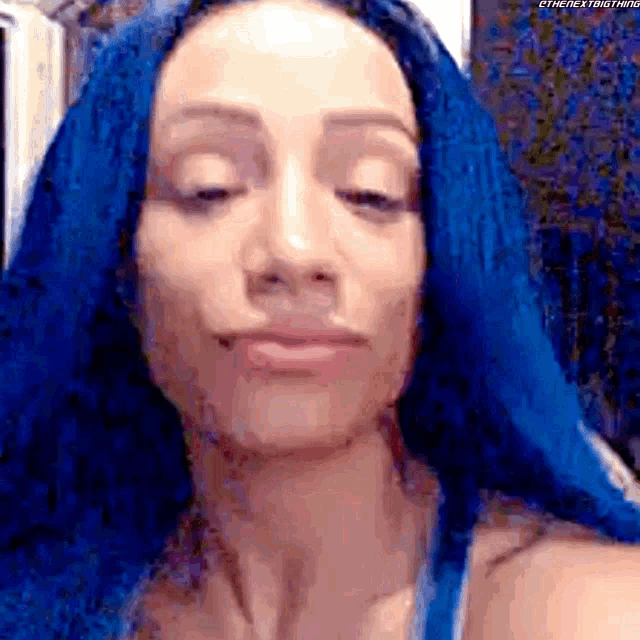 a close up of a woman 's face with blue hair .