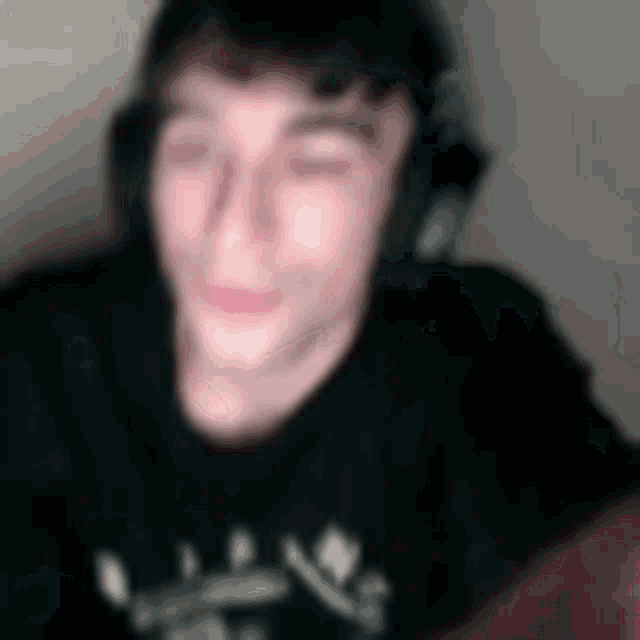 a blurry picture of a person wearing headphones and a black shirt .