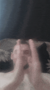 a blurry picture of a man 's face with his hands up