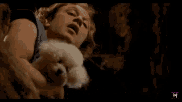 a man laying on a bed with a small white dog and the words " it chews the gum again "