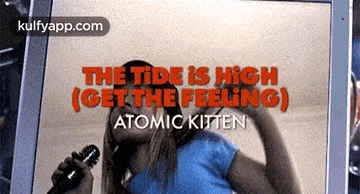 a woman singing into a microphone with the words the tide is high get the feeling atomic kitten