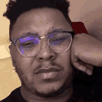 a man wearing glasses is making a funny face .