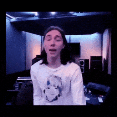 a young man wearing a white shirt with a picture of a girl on it