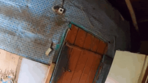 a dirty room with a door and a tiled wall