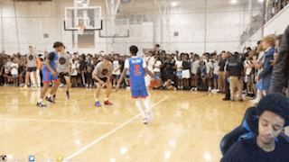 a man in a blue jersey with the number 2 on it stands on a basketball court