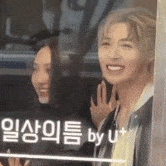 a man and a woman are smiling and waving at each other .