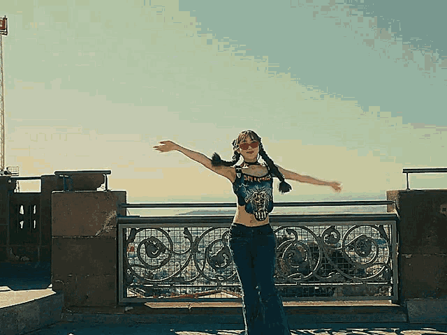 a woman wearing a metallica shirt stands on a balcony