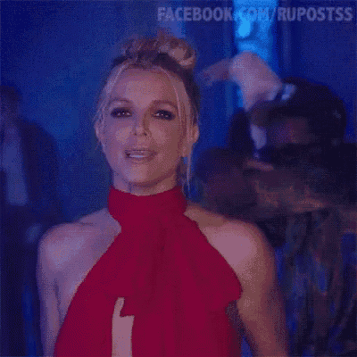 a woman in a red dress is standing in front of a blue background .