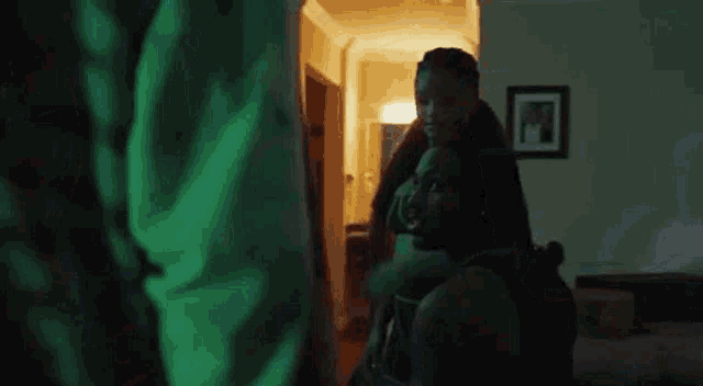 a man and a woman are hugging in a dark room .