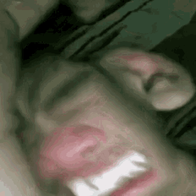 a close up of a person 's face with their mouth open and their teeth visible .