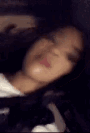 a close up of a woman 's face with her eyes closed and her mouth open .