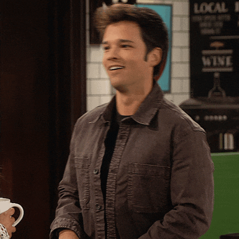 a man in a gray jacket is smiling in front of a sign that says local wine