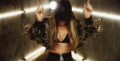 a woman wearing a black hat and a crop top is dancing