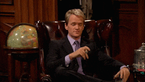 a man in a suit and tie is sitting in a chair with the word hot above him