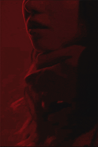 a man is licking a woman 's neck in a red light .