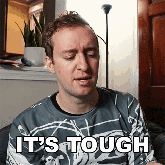 a man wearing a sweatshirt that says it 's tough