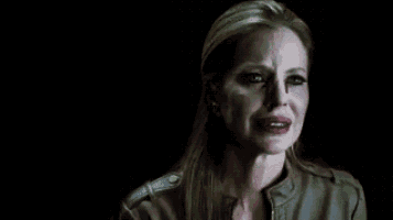 a woman in a leather jacket is crying in the dark .