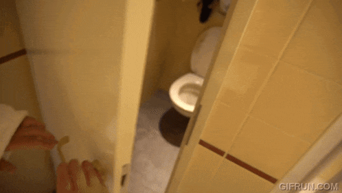 a toilet in a bathroom with gifrun.com on the bottom right