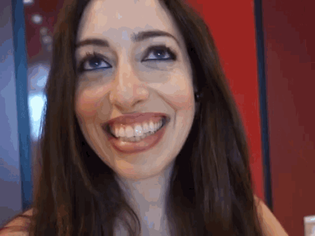 a close up of a woman 's face with a big smile