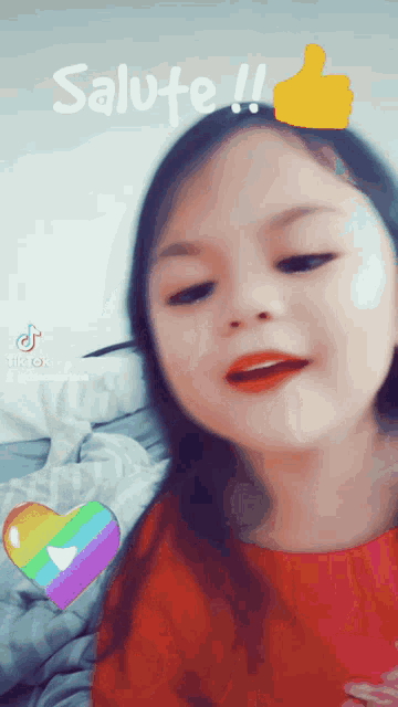 a little girl giving a thumbs up with the word salute behind her