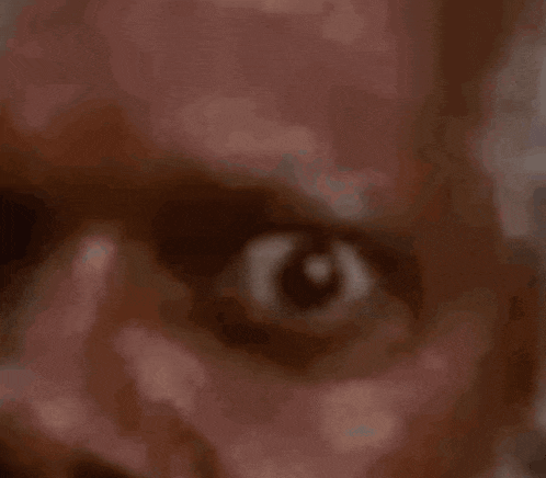 a close up of a man 's eye with a blurred background